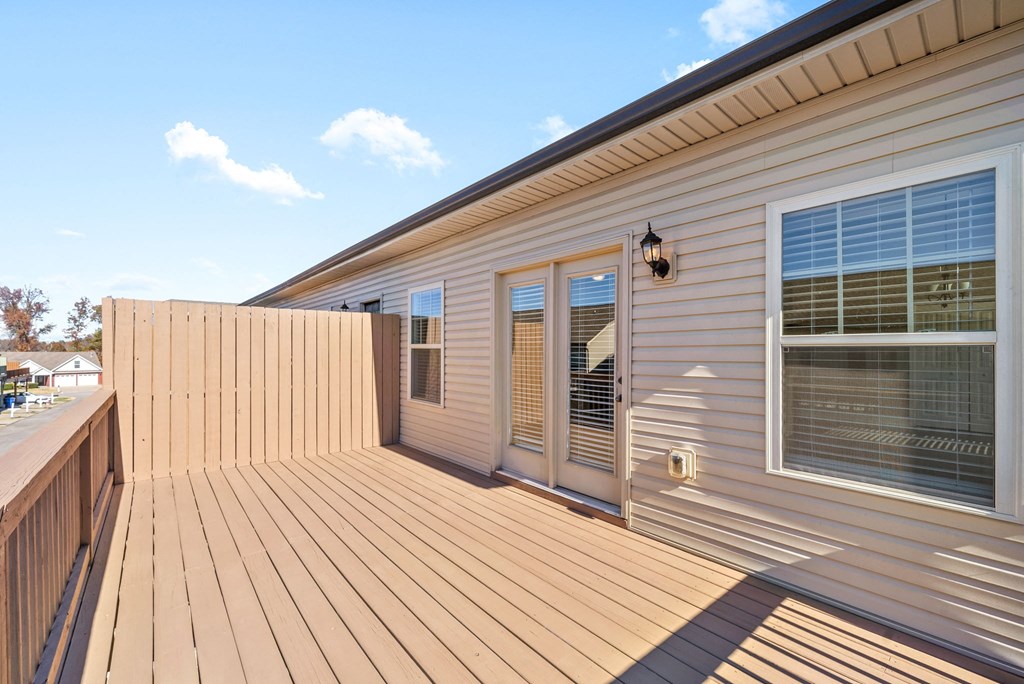the deck off the master bedroom has a view of the yard and the house