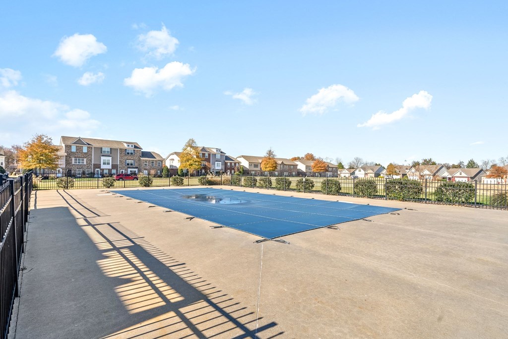 an empty blue tennis court in the middle of a parking lot