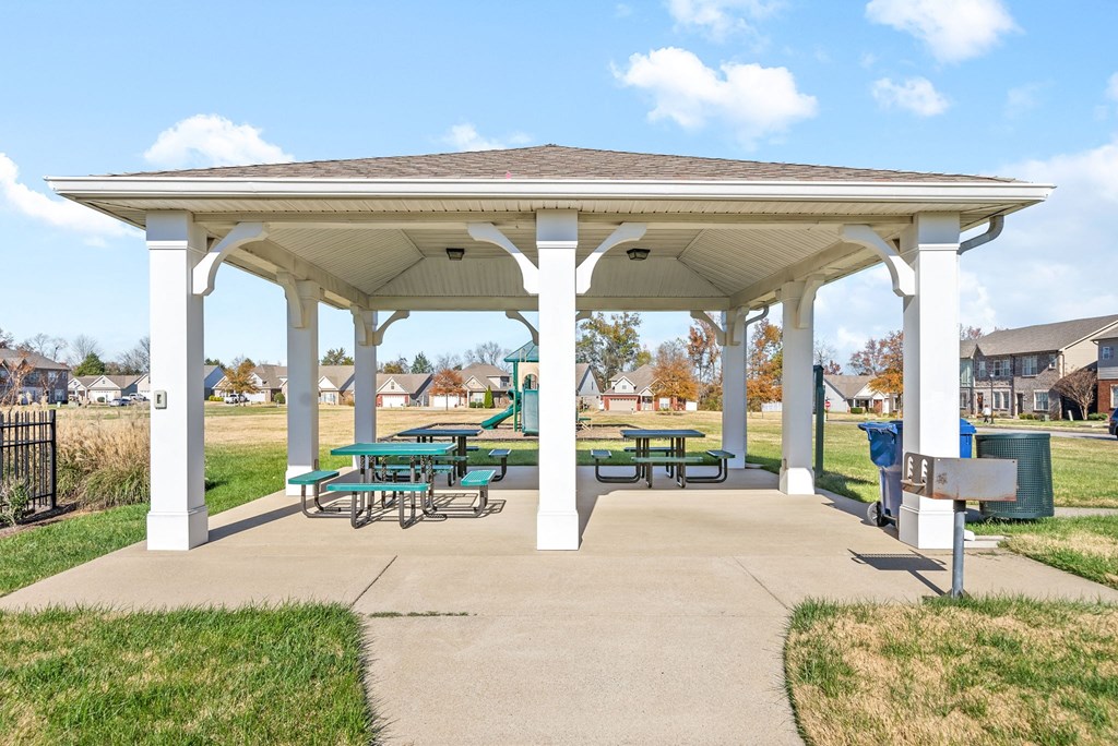 a pavilion with picnic tables in a park