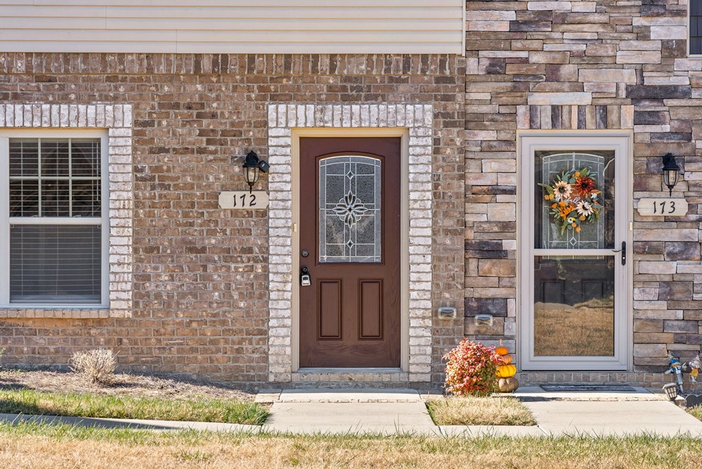 a brick house with a brown door and two windows
