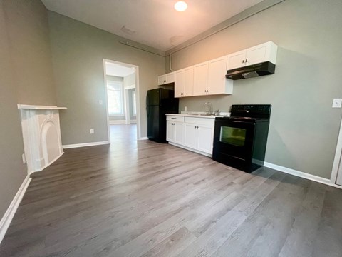 A kitchen with black appliances and white cabinets.