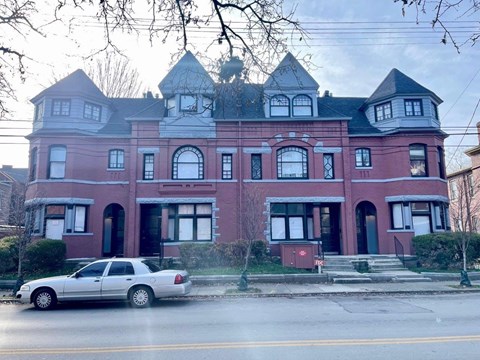 A large red building with a white car parked in front.