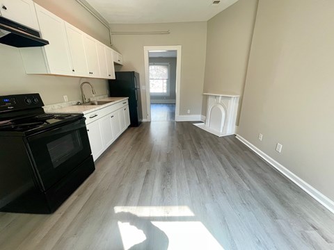 A kitchen with black appliances and white cabinets.