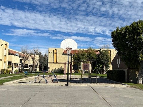 A basketball court with a basketball hoop and a building in the background.