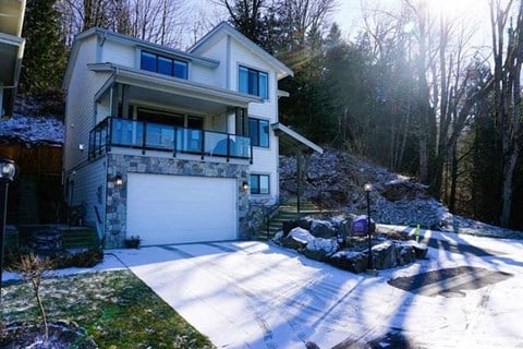 a white house with a garage in the snow