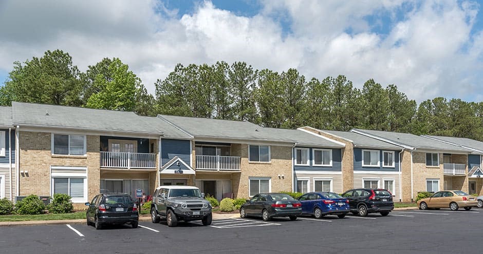 exterior roadway showing parking spots and cars in front of the building