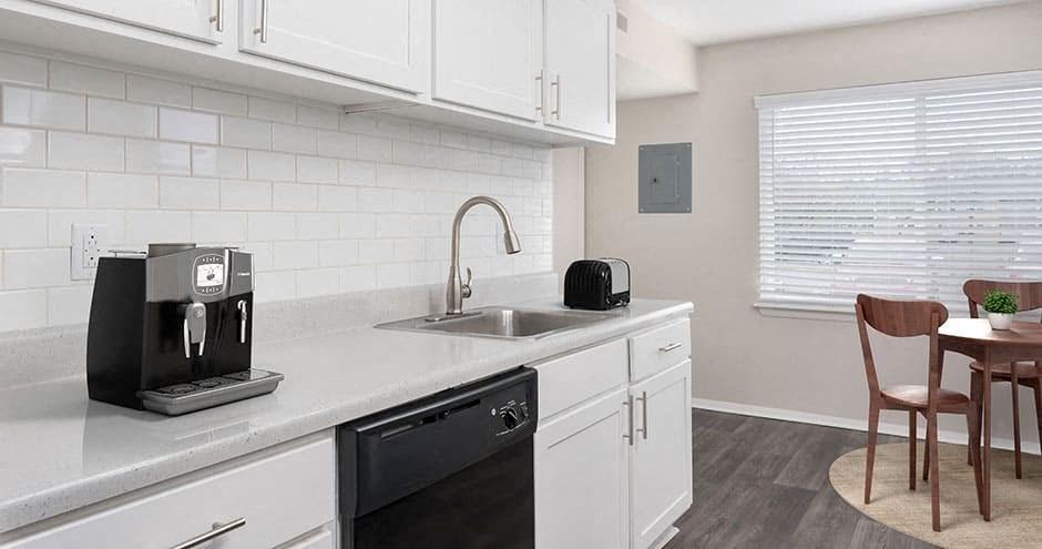 apartment kitchen with white cabinets and black appliances