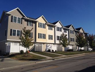 a row of condominiums on the side of a street