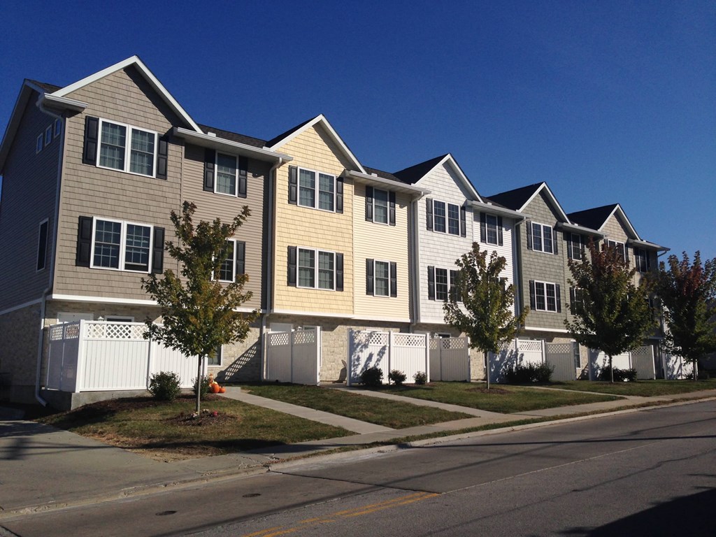 a row of condominiums on the side of a street