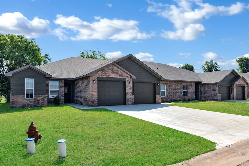 a brick house with a driveway and a fire hydrant
