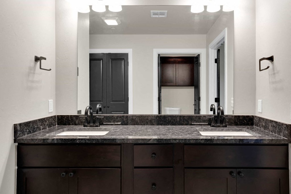 a bathroom with two sinks and a large mirror