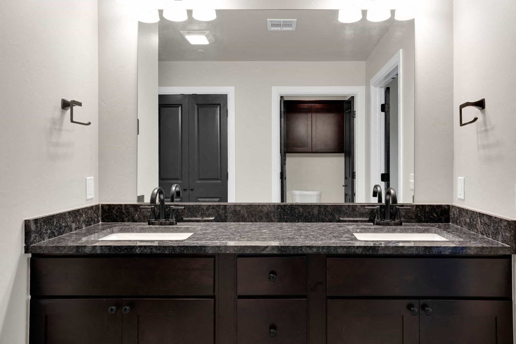 a bathroom with two sinks and a large mirror