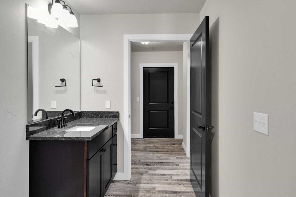 a bathroom with a sink and a door to a hallway