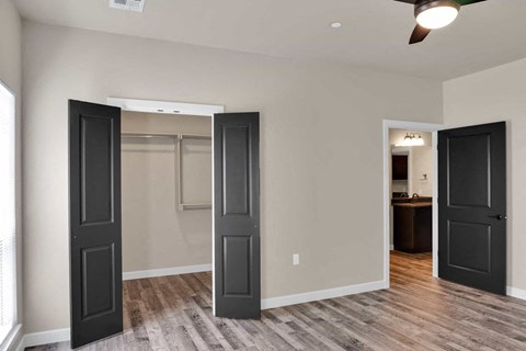 a renovated living room with black doors and a mirrored closet