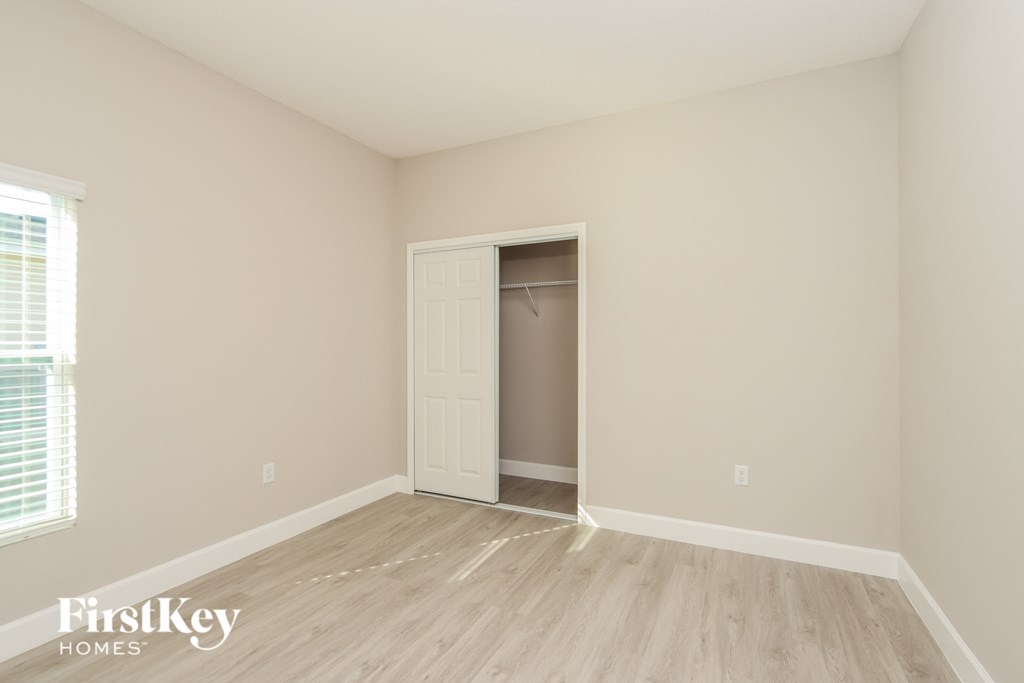 a bedroom with a closet and a wooden floor