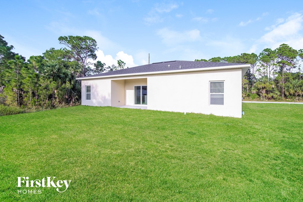 a small white house with a grassy yard in front of it