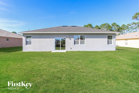 a white house with a grassy yard and a blue sky
