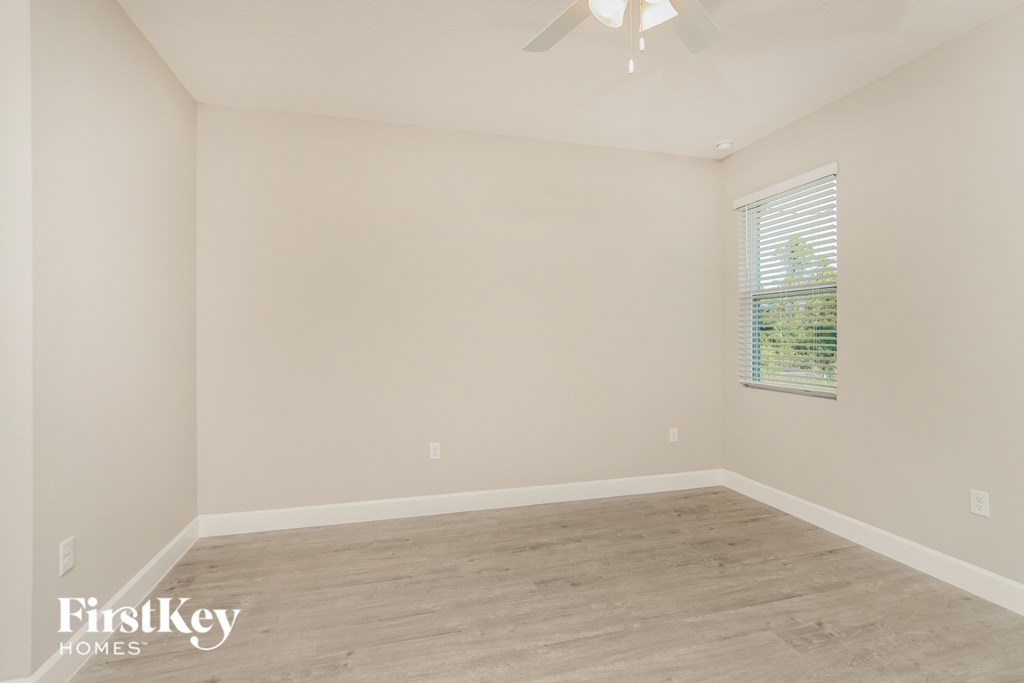 a bedroom with a wood floor and a ceiling fan