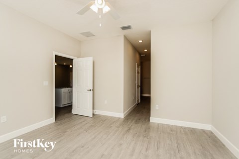 a living room with white walls and a ceiling fan