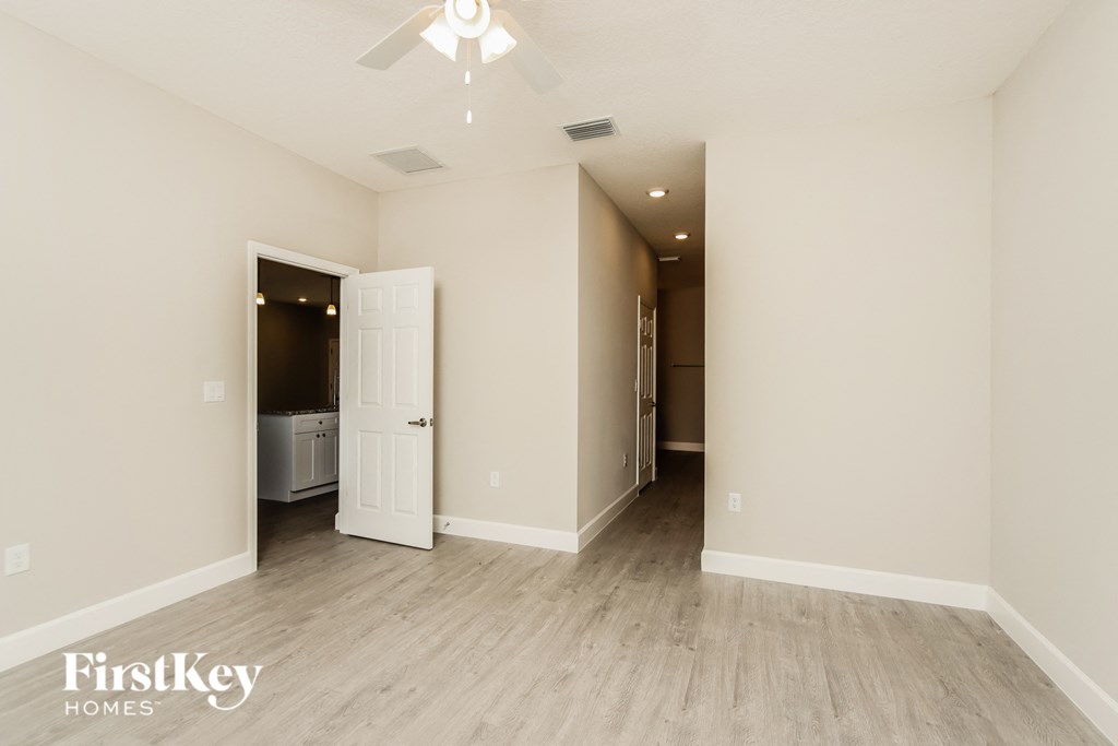 a living room with white walls and a ceiling fan