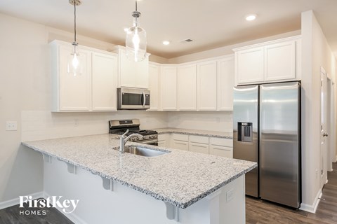 a kitchen with white cabinets and a granite counter top