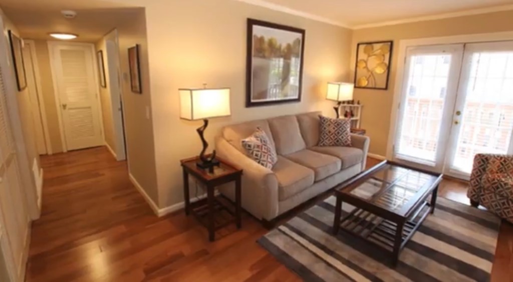 A living room with a couch, coffee table, and lamp.