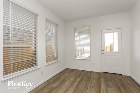 the living room of a house with white walls and a white door and windows