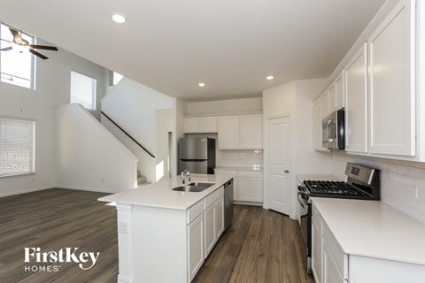 a kitchen with white cabinets and white counter tops and a sink