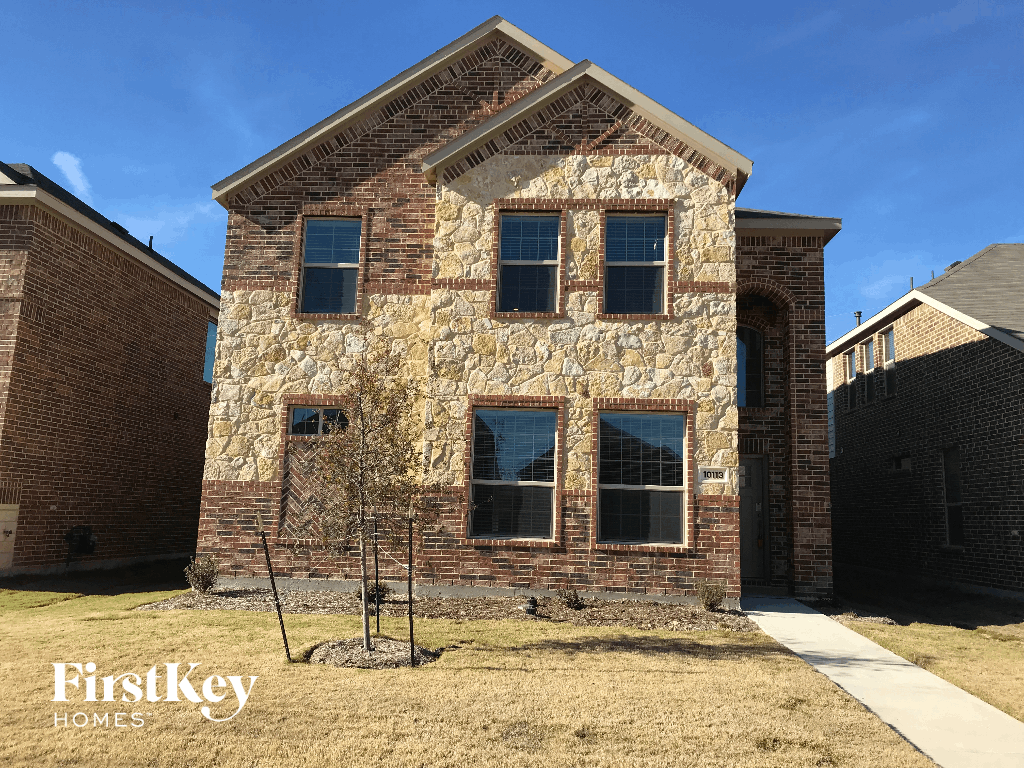 a brick house with a tree in front of it