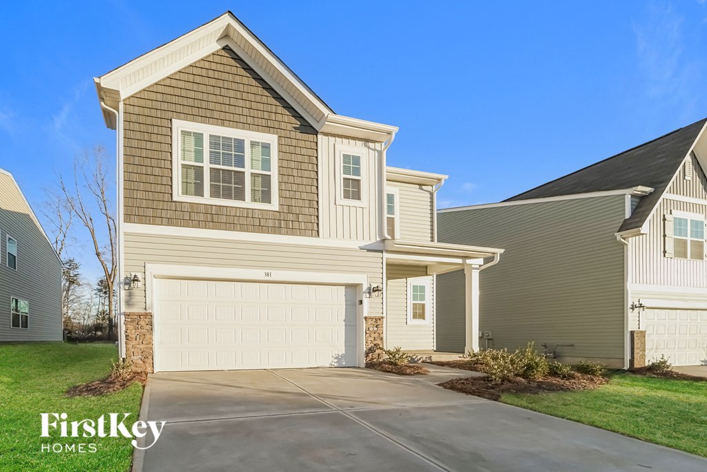 a beige and tan house with a white garage door