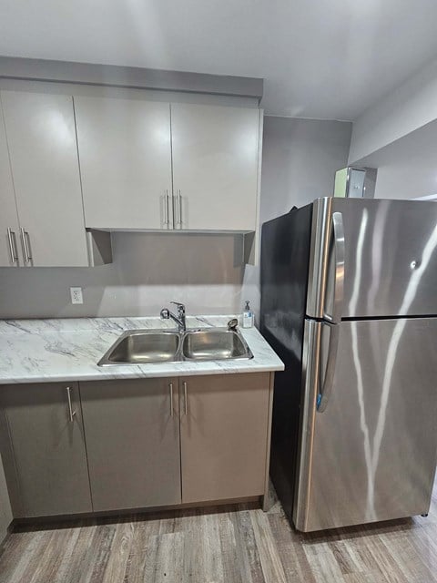 A kitchen with a sink and a refrigerator.