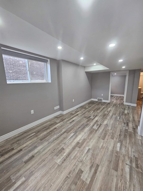 A room with wooden flooring and a window.