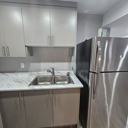 A kitchen with a sink and a refrigerator.