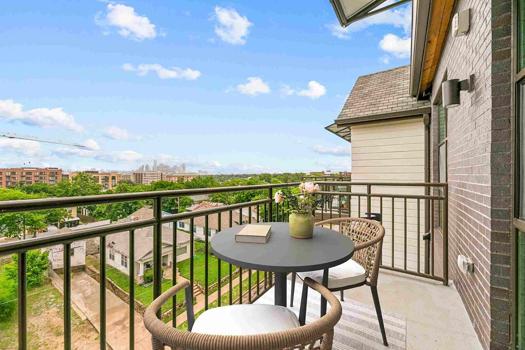 a balcony with a table and chairs and a view of the city