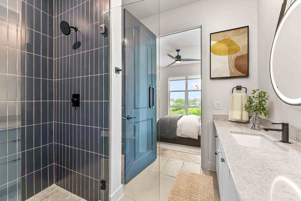 a bathroom with a shower and a bed in a room