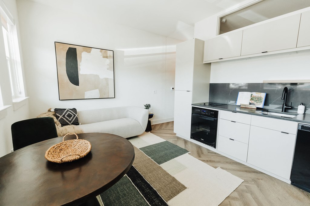 a living room with a table and a kitchen