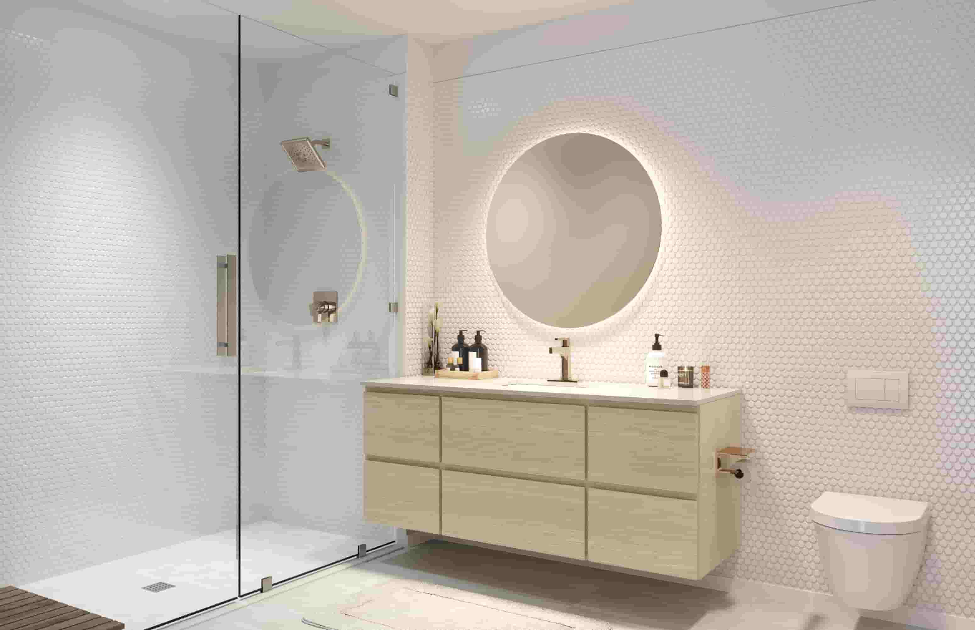 A bathroom with a white toilet, a round mirror, and a wooden cabinet.