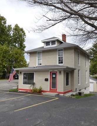 a yellow house with a red door and an flag