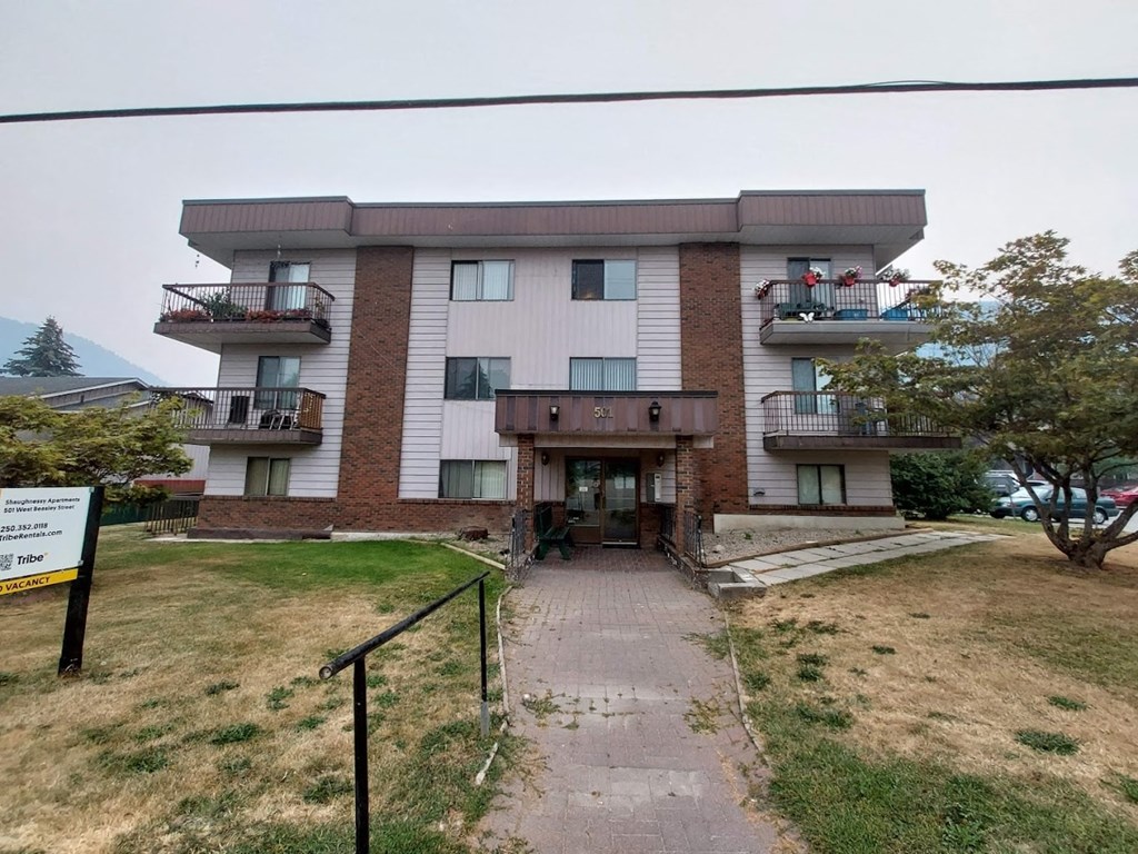the front of an apartment building with a walkway and stairs