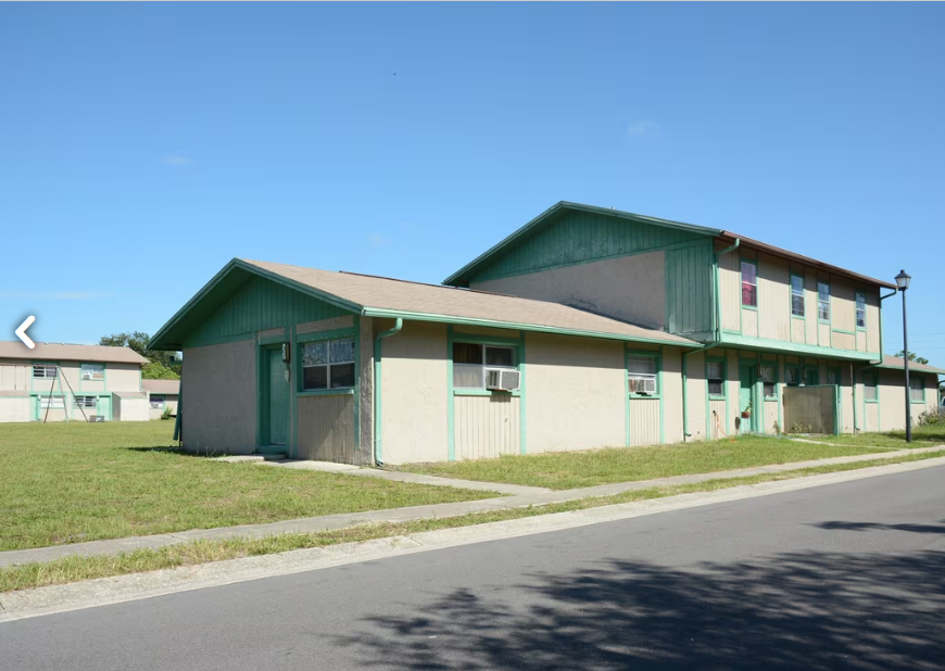 a green and white building with a street in front of it