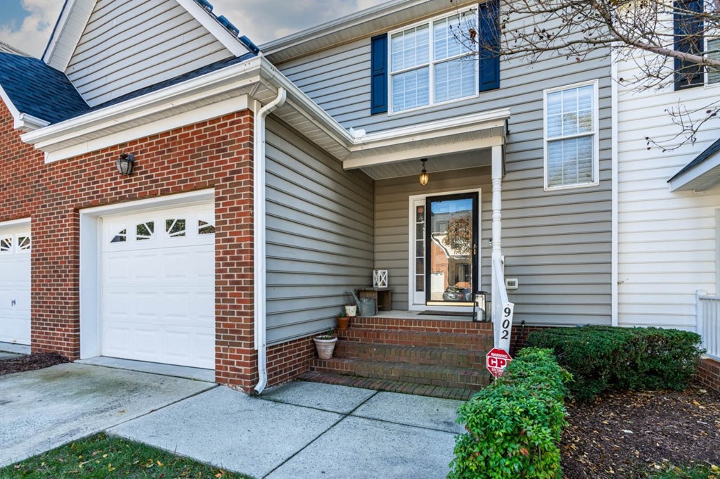 a white and brick house with a white garage door