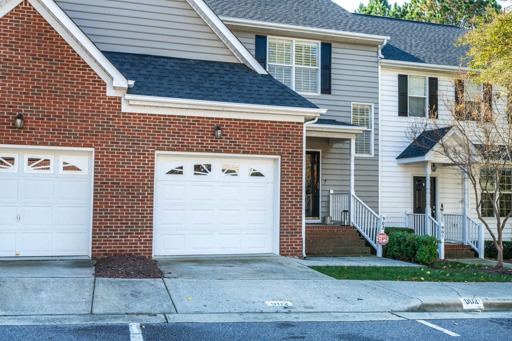 a white garage door in front of a brick house