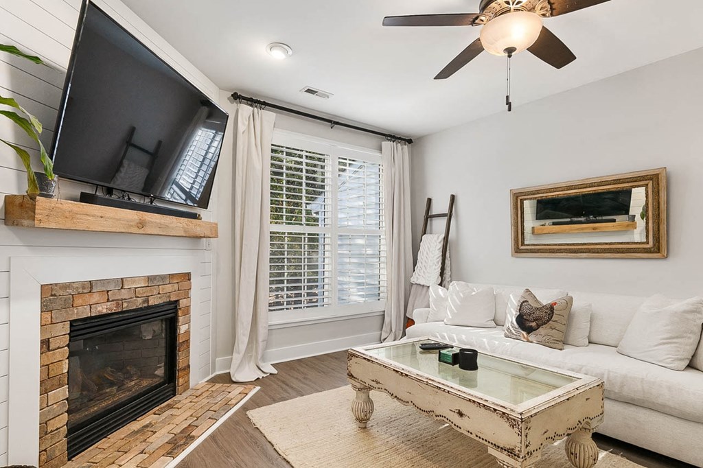 a living room with a couch and a fireplace     and a television