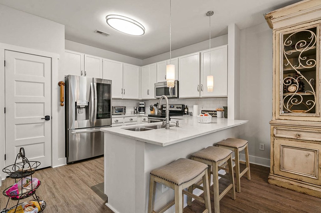 a kitchen with a large island with three stools