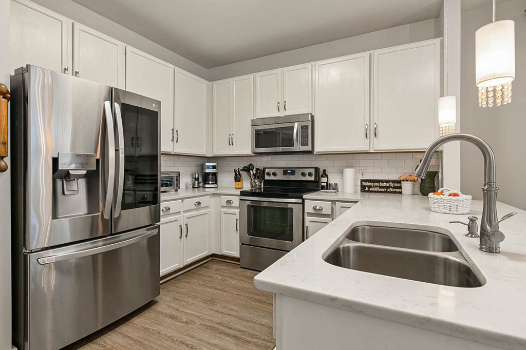 a kitchen with stainless steel appliances and white cabinets