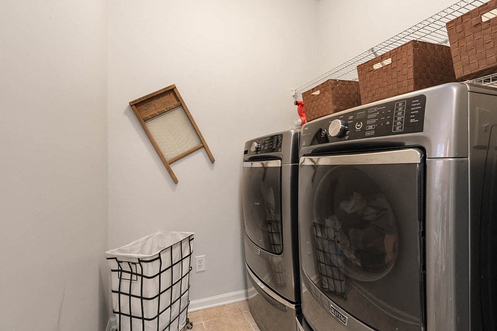 a washer and dryer in a laundry room with a window and a mirror
