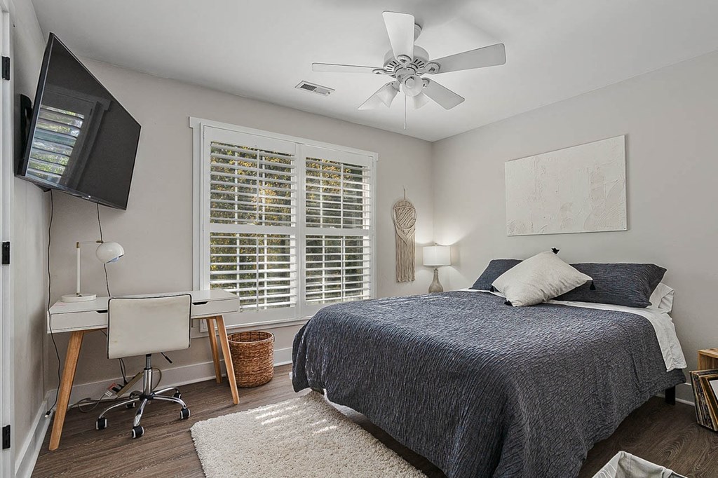 a bedroom with a bed and a ceiling fan
