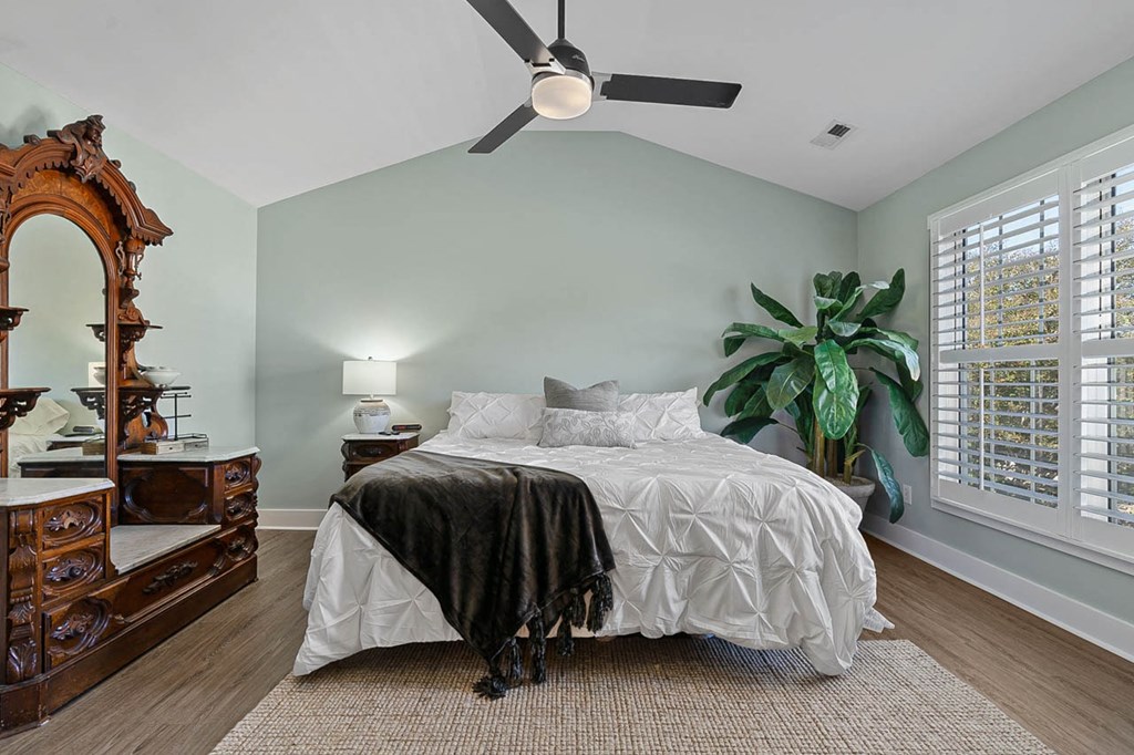 a bedroom with a bed and a ceiling fan
