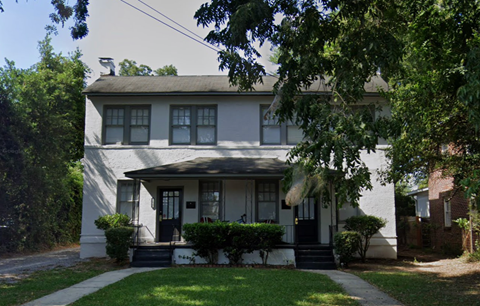 a white house with a sidewalk in front of it