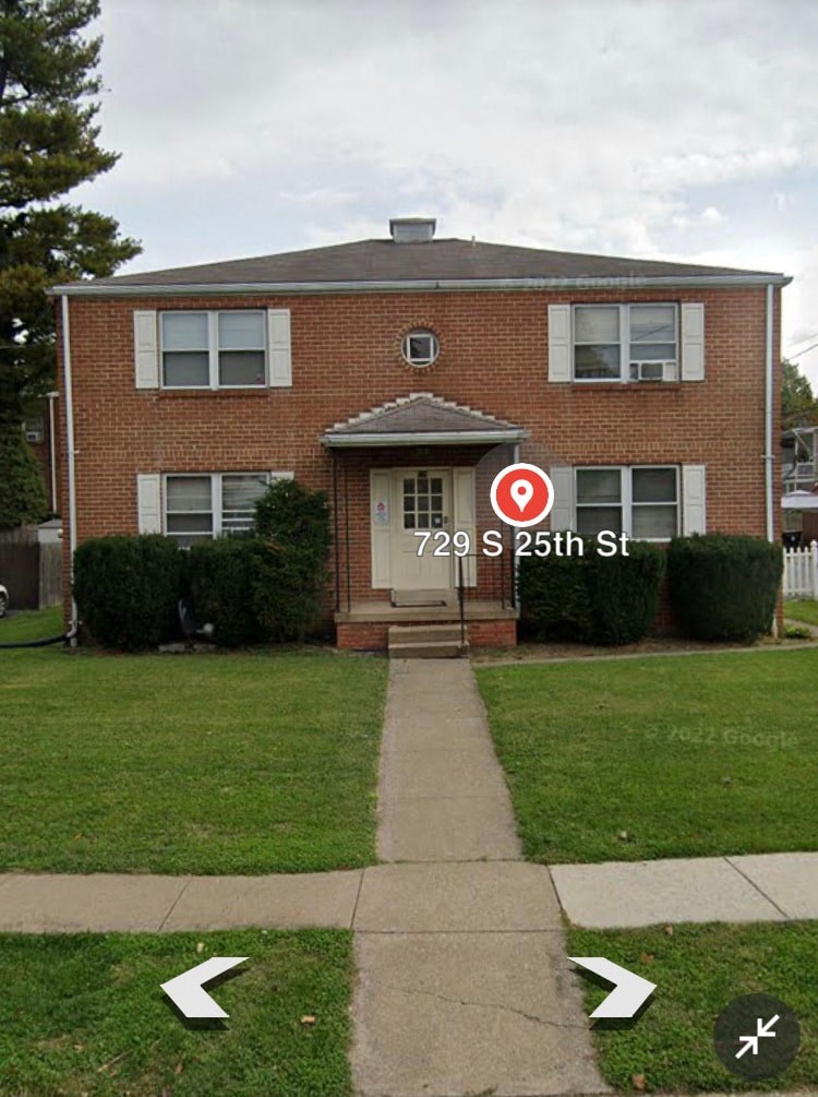 a house with a street sign in front of a sidewalk